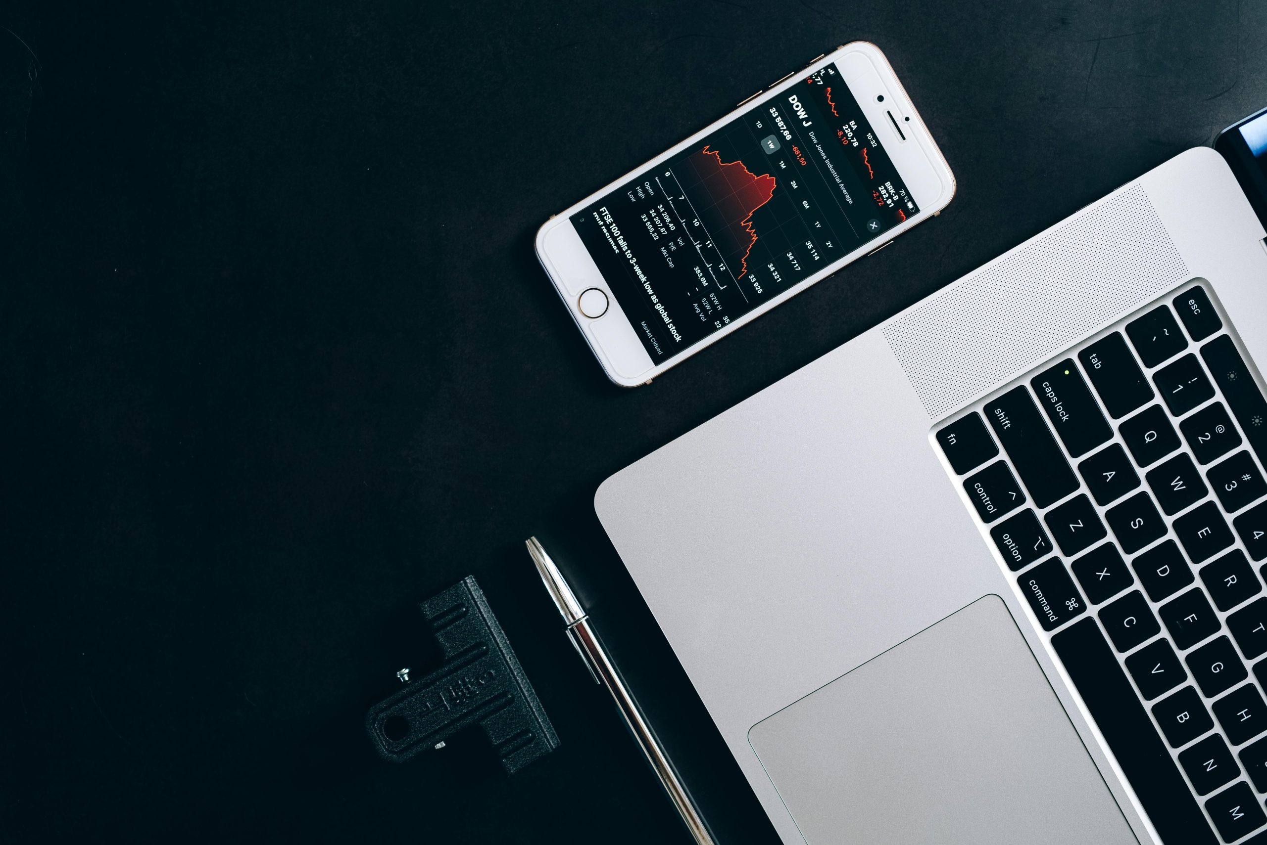 Modern workstation setup showcasing laptop, smartphone, and financial data for business use.