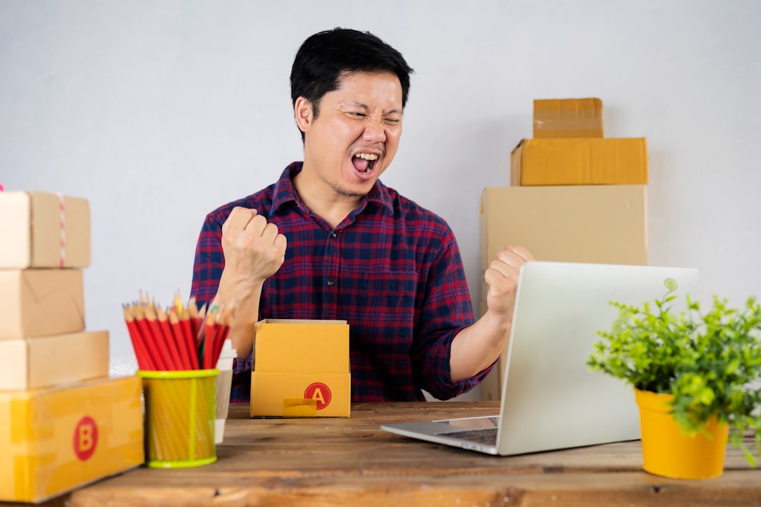 a man sitting at a table in front of a laptop